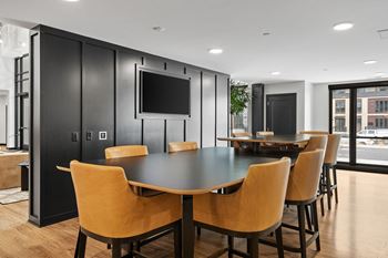 a conference room with a table and chairs and a television